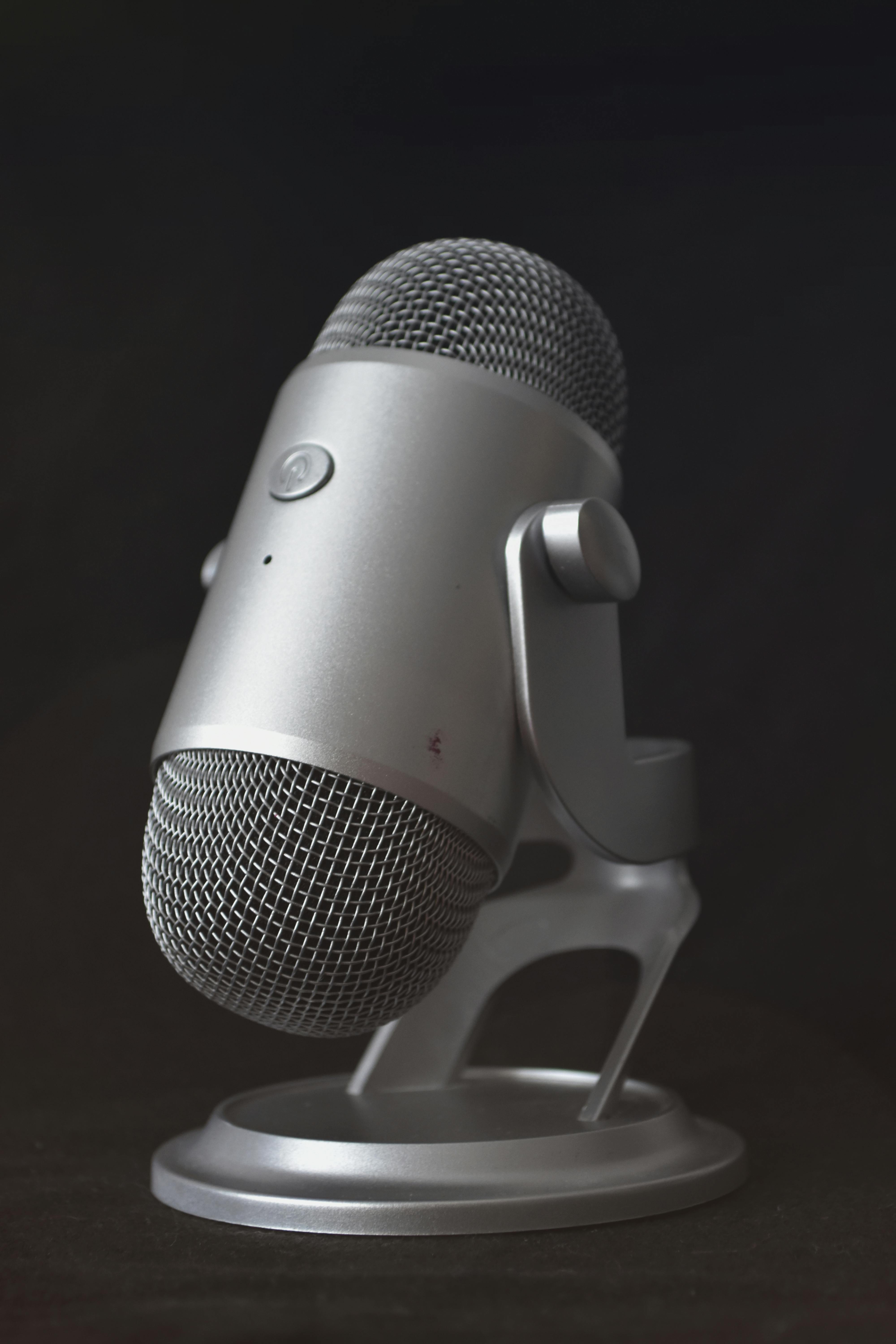 Detailed shot of a metallic microphone on a stand, ideal for studio recordings.